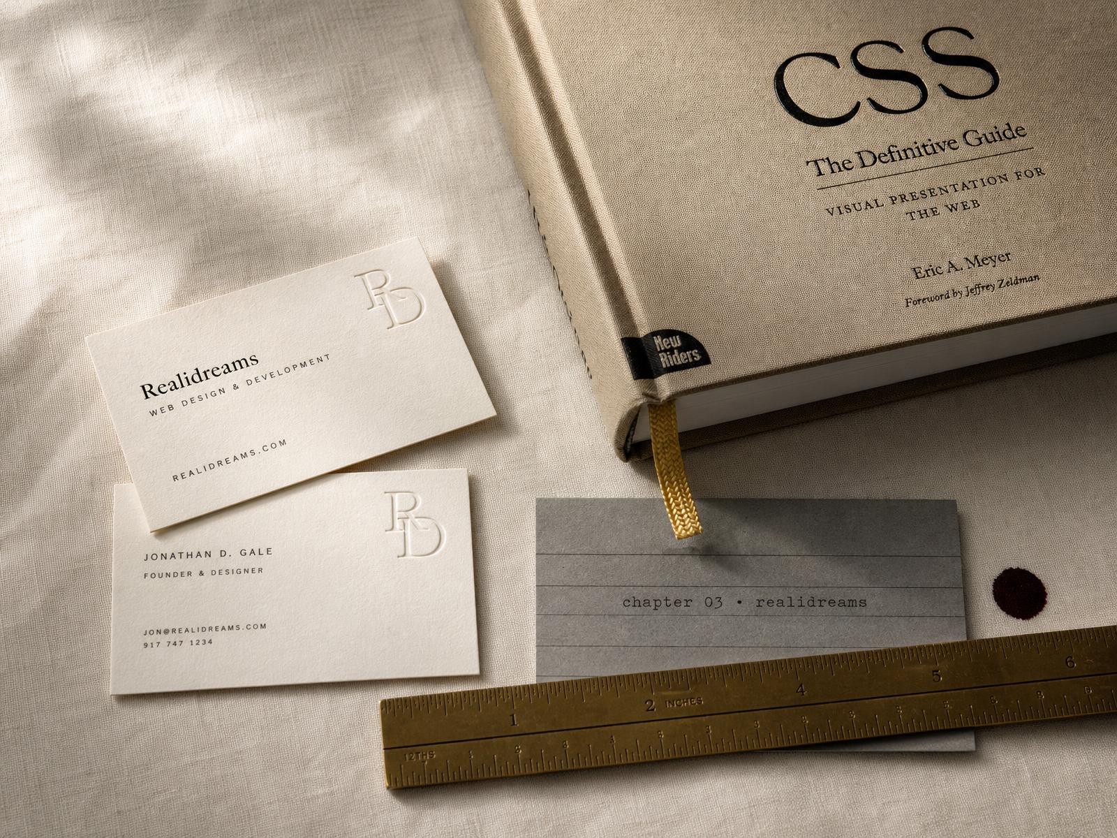 Illustration of an independent design studio desk: stacked brand identity samples, an open magazine of logo studies, a brand mark on a display podium, and a laptop showing a website mockup, representing running a full-service studio.